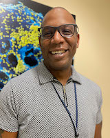 A headshot of Thomas Brown in a gray shirt.