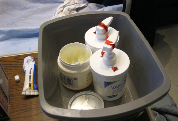 Photo of bucket with skin creams and medicines