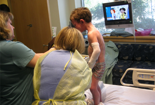 Photo of boy receiving moisturizing skin treatment for eczema