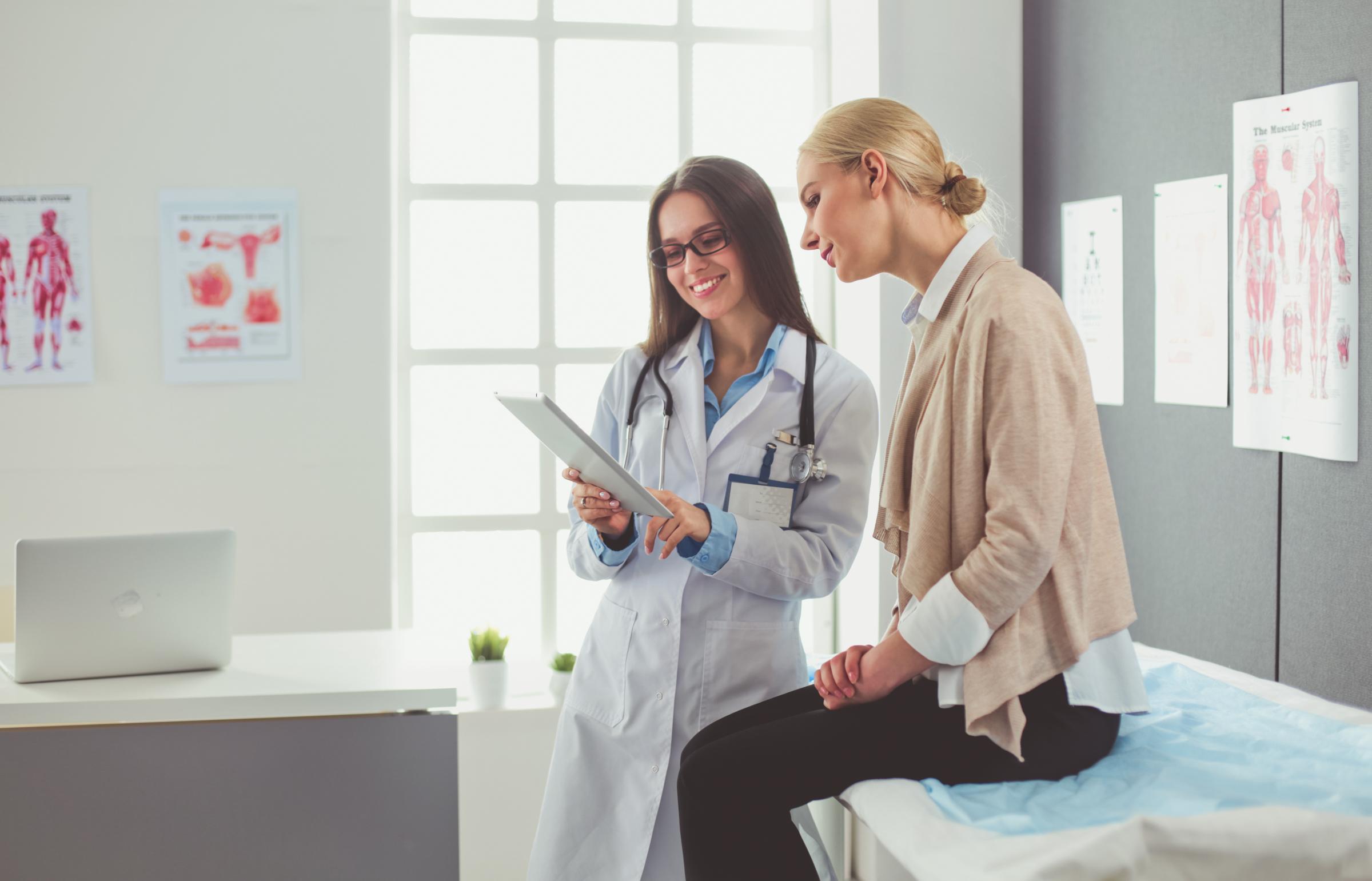 Doctor and patient discussing something while patient is sitting at the table.