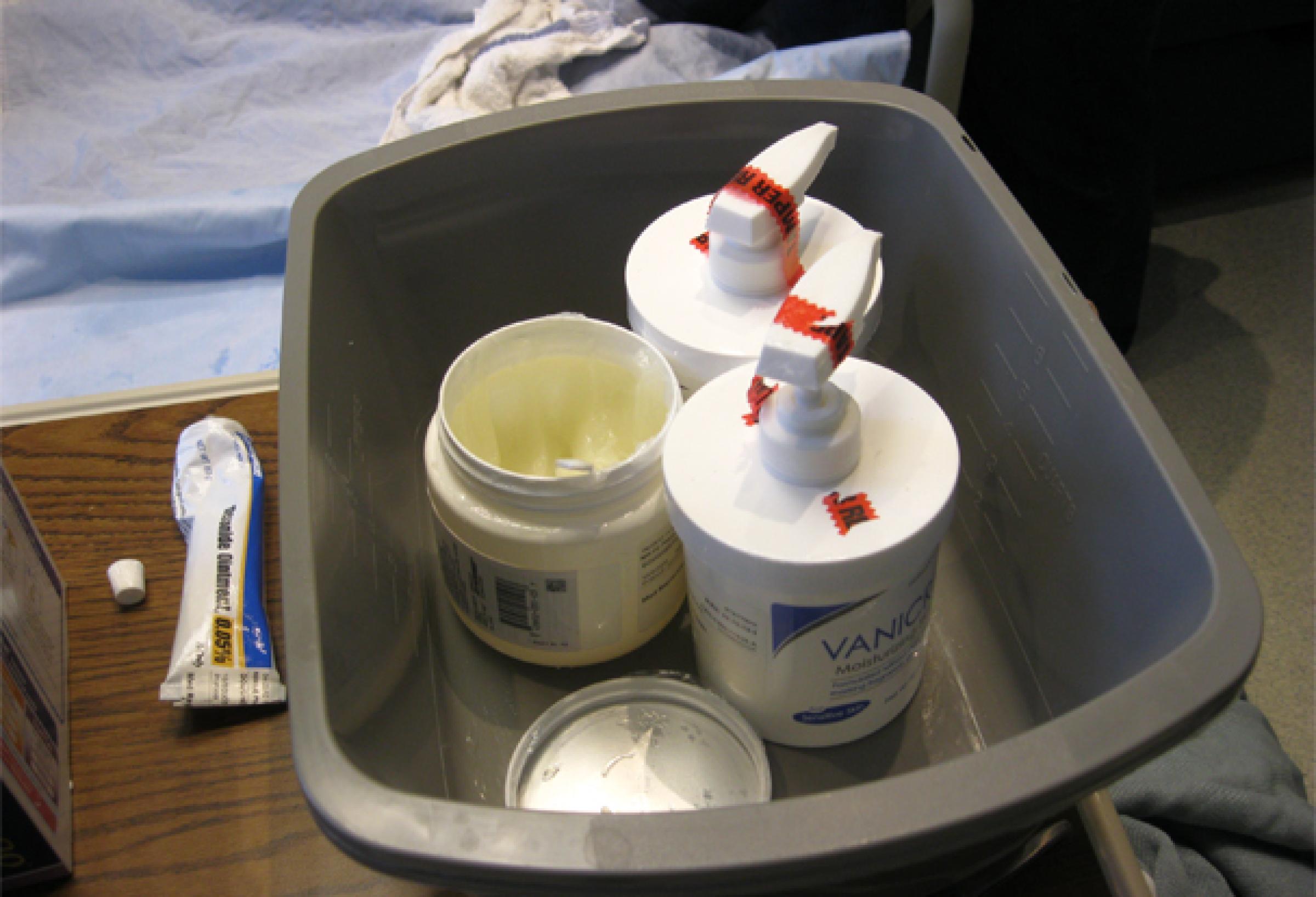 Photo of bucket with skin creams and medicines