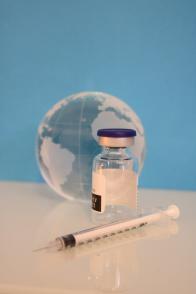 A Syringe, a Vaccine Bottle, and glass Globe