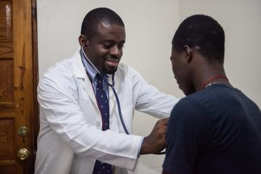 Dr. Samuel Pierre uses a stethoscope to examine a patient’s lungs at the GHESKIO clinic in Port-au-Prince, Haiti.