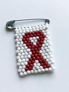 A white and red, beaded HIV awareness ribbon pin