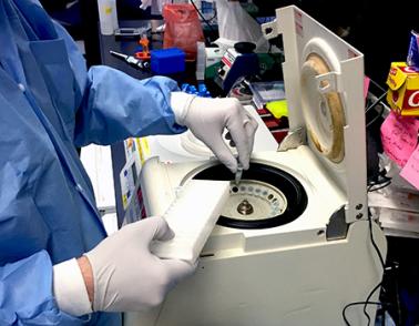 Photo of Zika virus researcher at the NIAID Vaccine Research Center loading samples into a microcentrifuge.