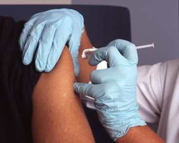 nurse administers a vaccine in a person's arm