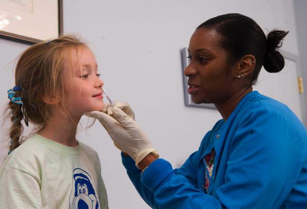 Nurse administers FluMist vaccine to a patient.