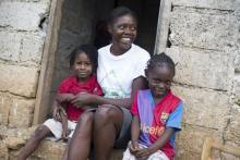 A health worker with children during a PEPFAR sponsored home health care visit in Haiti