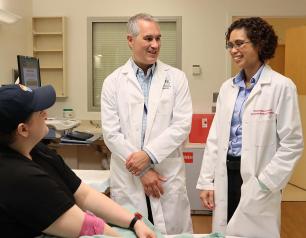 Researchers from the National Institutes of Health talk with a study participant at the NIH Clinical Center.