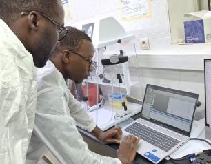 Two scientists are shown at the University of Sciences, Techniques, and Technologies of Bamako, Mali, performing testing on plasma specimens from patients.